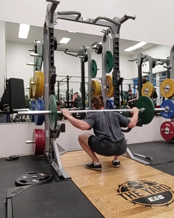 Nick squatting with a barbell in a rack