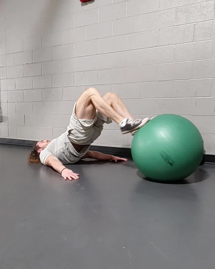Nick performing a leg curl on a stability ball